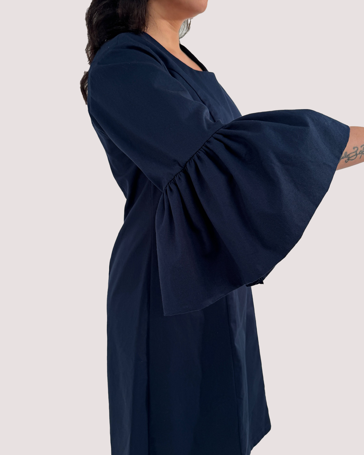 Blaue Volants als Ärmelsäume an einem Kleid aus Bio Baumwolle.