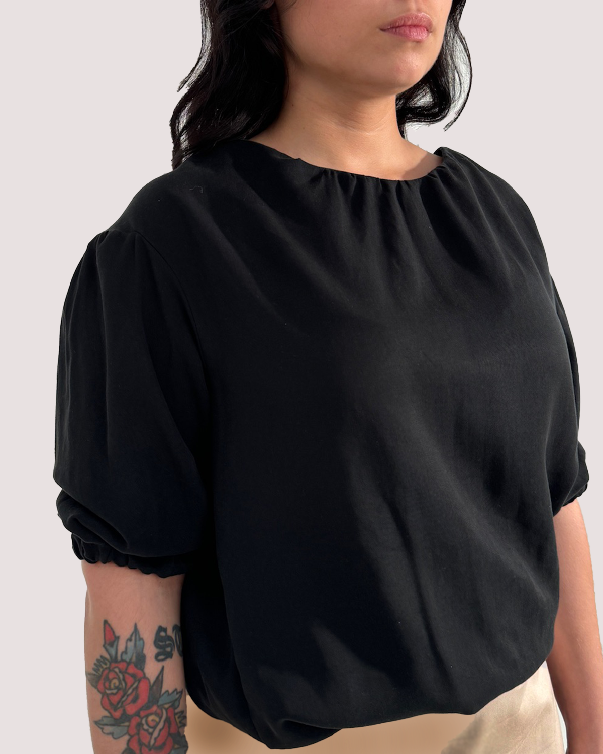 Seitenansicht eines schwarzen Shirts, mit elastischen Säumen, aus Lyocell.